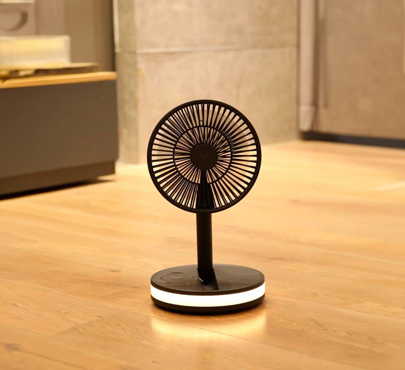 Akina Portable Fan running on a bedroom floor at night, base light casting a soft warm glow on the wood floor