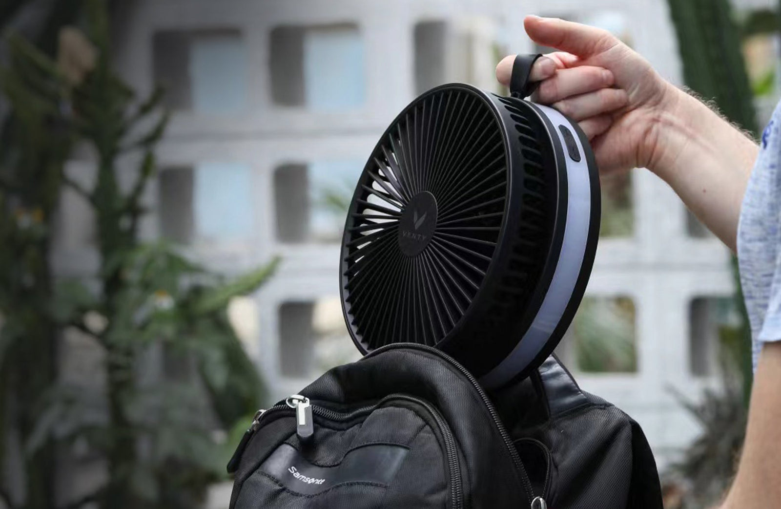 Top-down detail of three Akina Portable Fans in white, black, and blue showing the premium machined grille