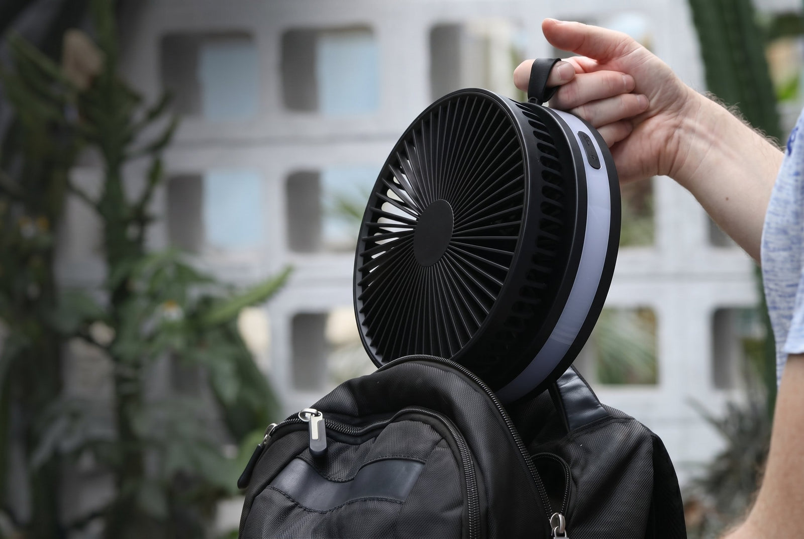 Top-down detail of three Akina Portable Fans in white, black, and blue showing the premium machined grille